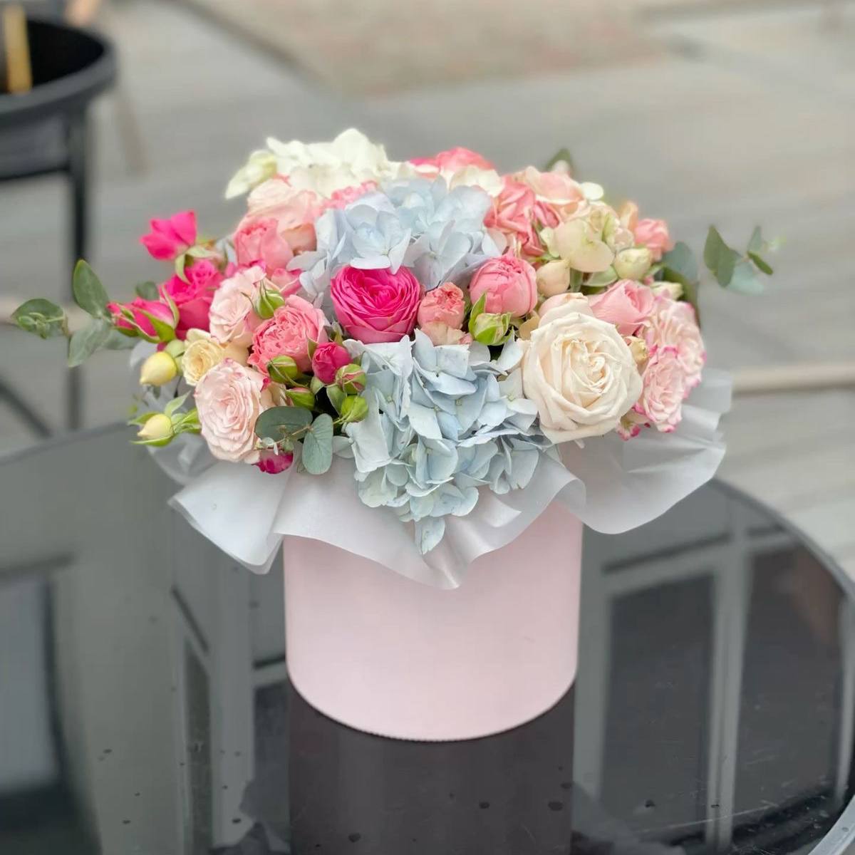 Bouquet in a box with roses and blue hydrangea 